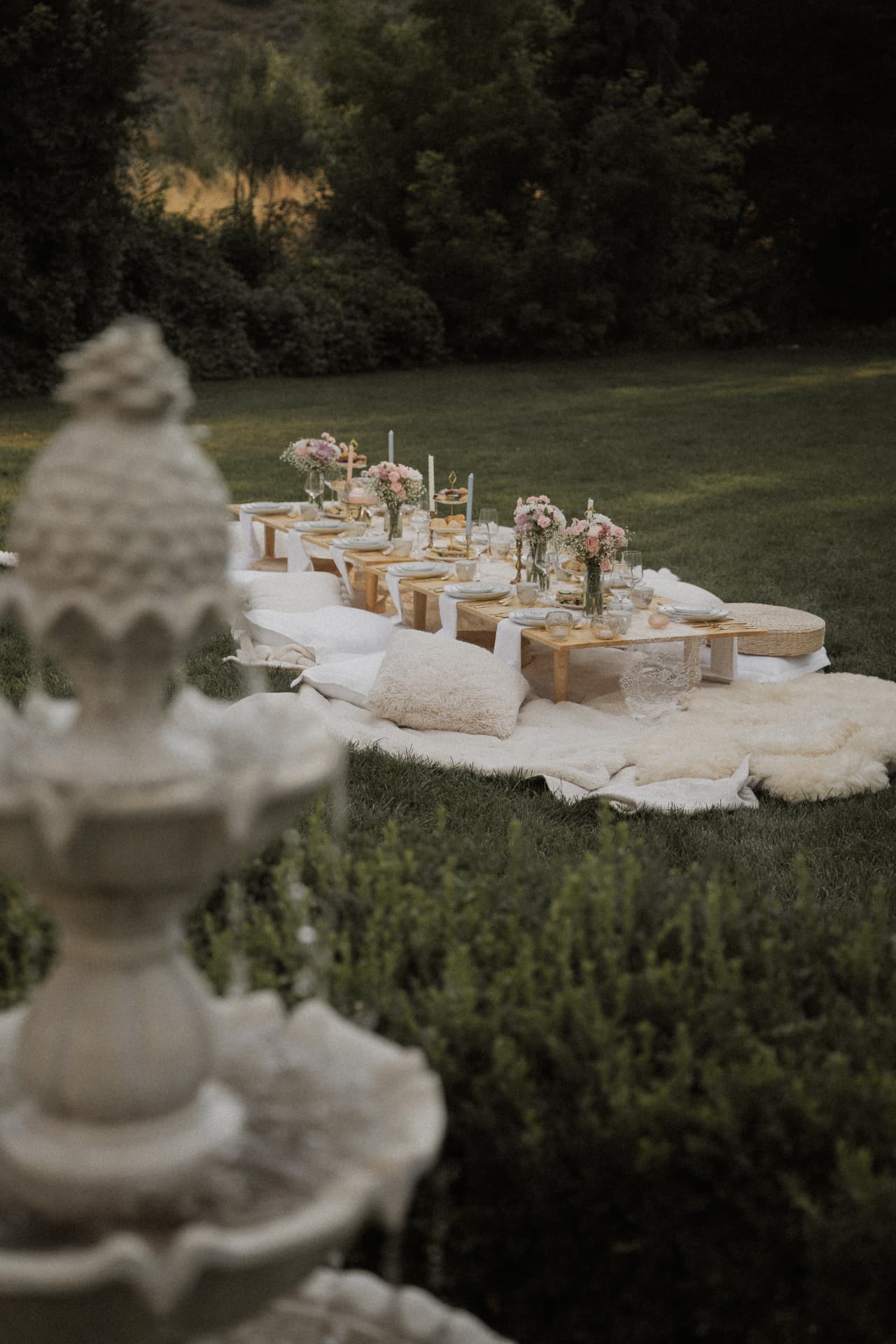 Picnic tables with flowers set behind a garden fountain